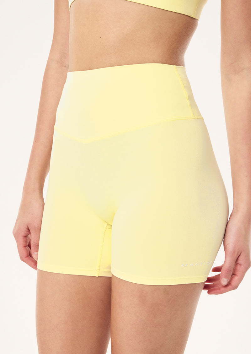 SIGNATURE 5 INCH BIKE SHORT IN SOFT YELLOW BY P.E NATION, WOMEN'S PILATES BIKE SHORT